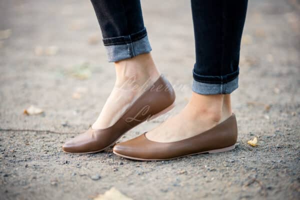 Braune Ballerinas auf nackter Haut