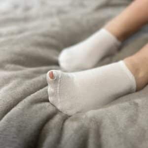 weiße Socken mit Loch
