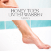 Nahaufnahme eines Fußes unter der Dusche, mit Wasser, das über die Haut fließt. Der Profilname 'Honey Toes unter Wasser – Video' ist in eleganter Schrift im Bild platziert.