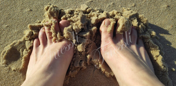 Nackte Füße am Strand.